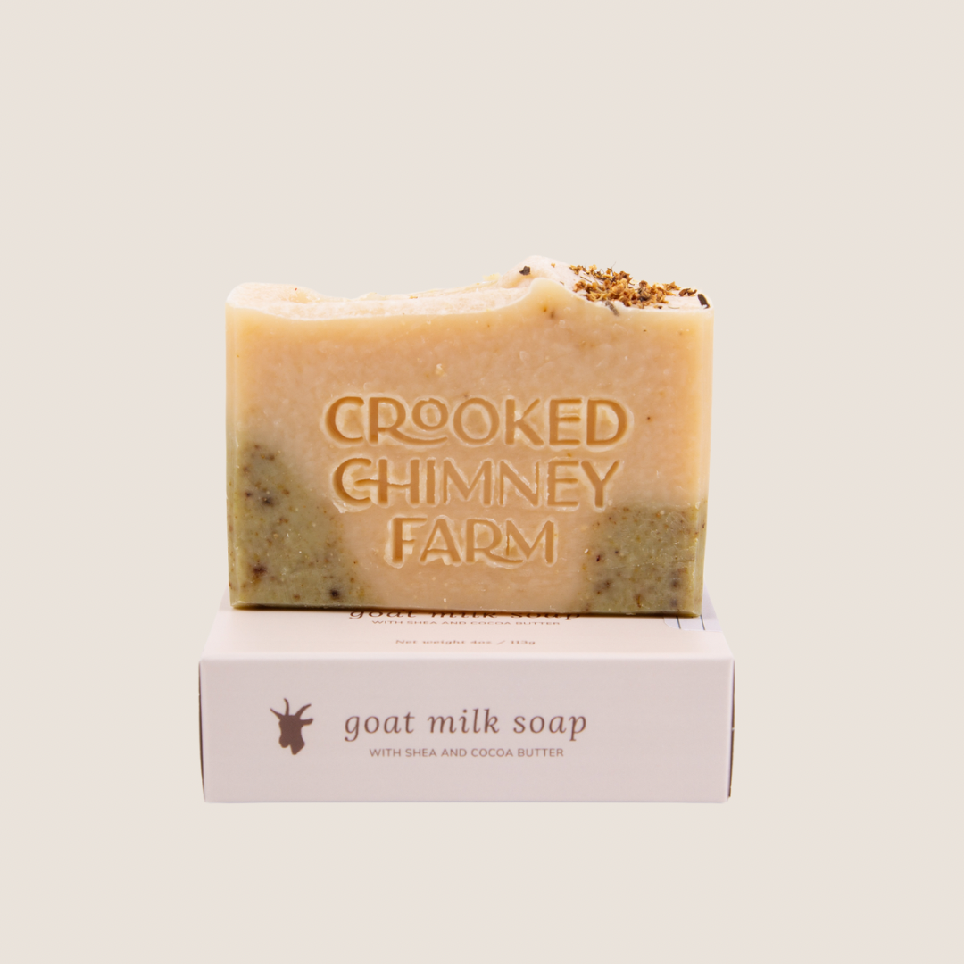 A bar of crooked chimney farm lily of the valley goat milk soap set on top of soap box