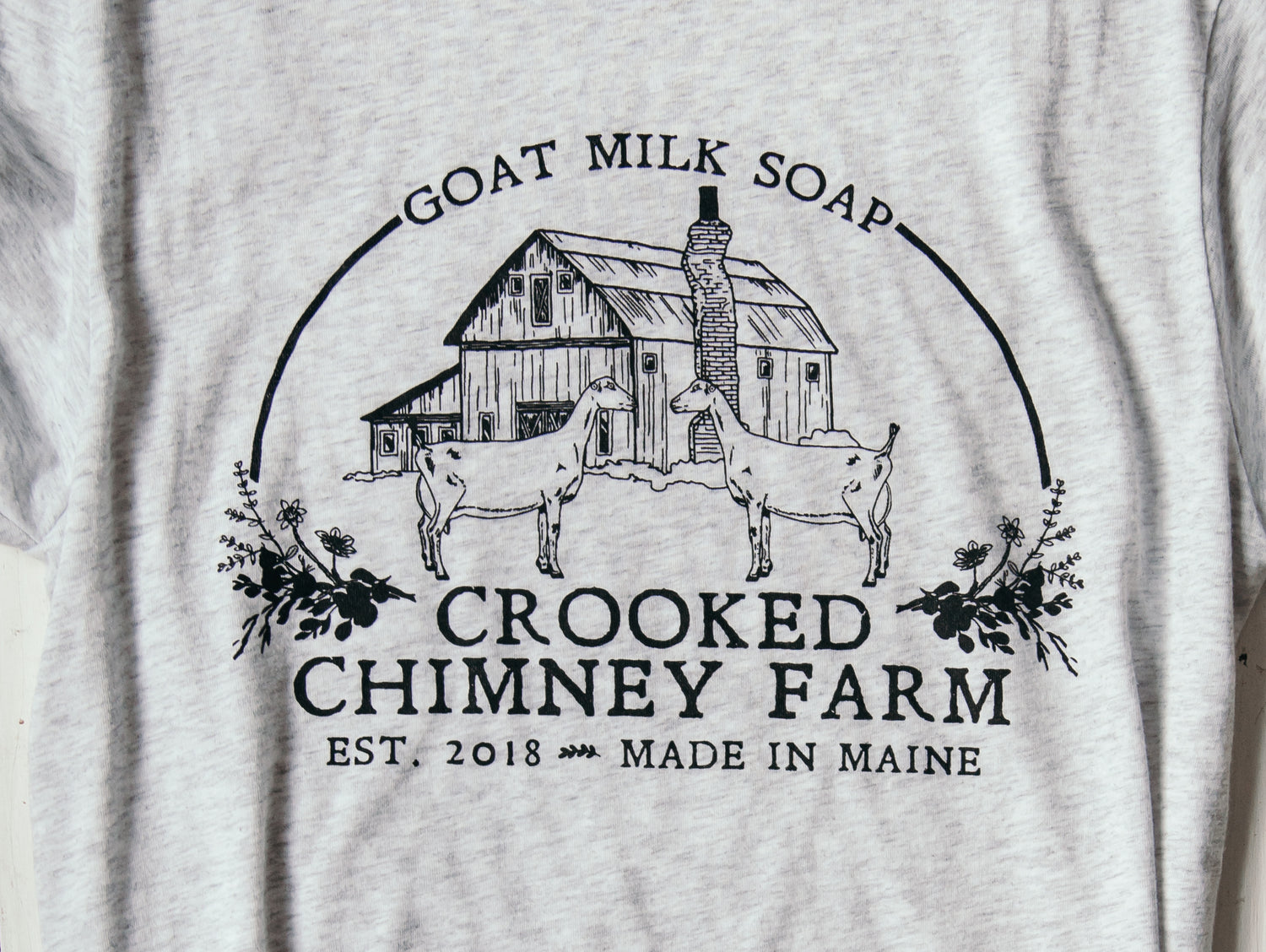 close up of crooked chimney farm tee logo on shirt.