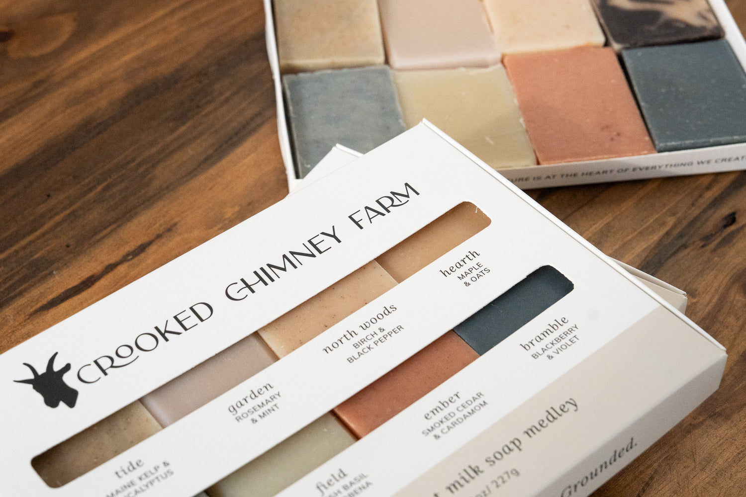 Crooked Chimney Farm Goat Milk Soap Medley Gift Box on Wood background. One closed box and one opened box. 