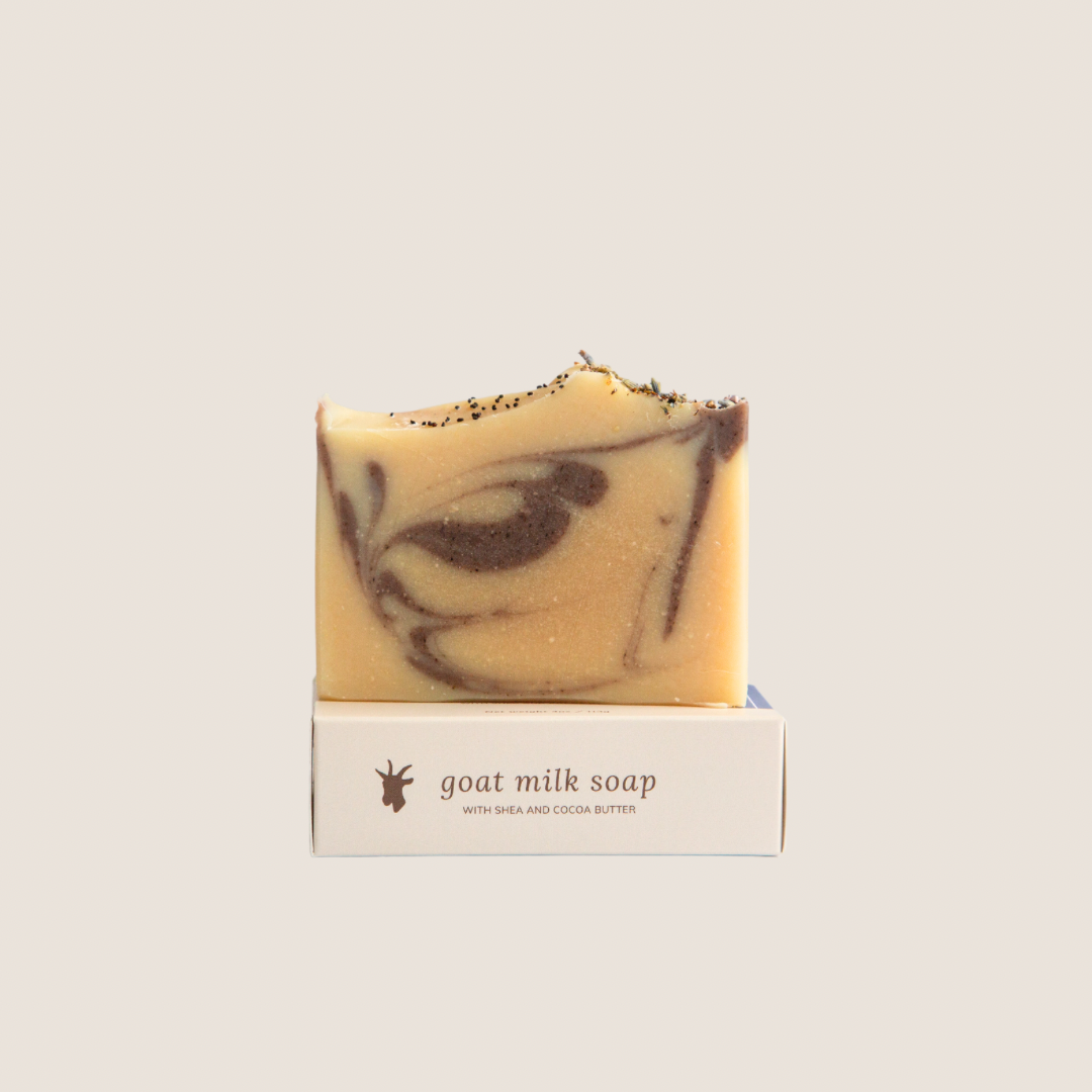 A bar of lavender clove goat milk soap on top of it&