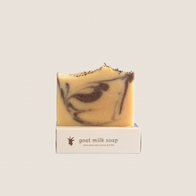 Load image into Gallery viewer, A bar of lavender clove goat milk soap on top of it&#39;s soap box
