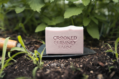 a bar of crooked chimney farm Garden soap on a trowel in a garden