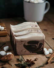 Load image into Gallery viewer, 4 bars of cinnamon cocoa soap that have brown swirls with white tops. 
