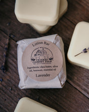 Load image into Gallery viewer, lavender lotion bar wrapped in tissue paper with ingredient label 
