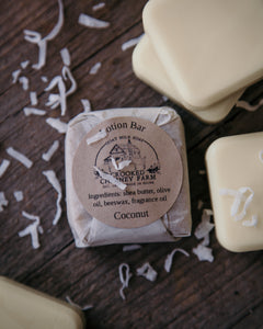 crooked chimney farm coconut lotion bar wrapped in tissue paper with ingredient label.
