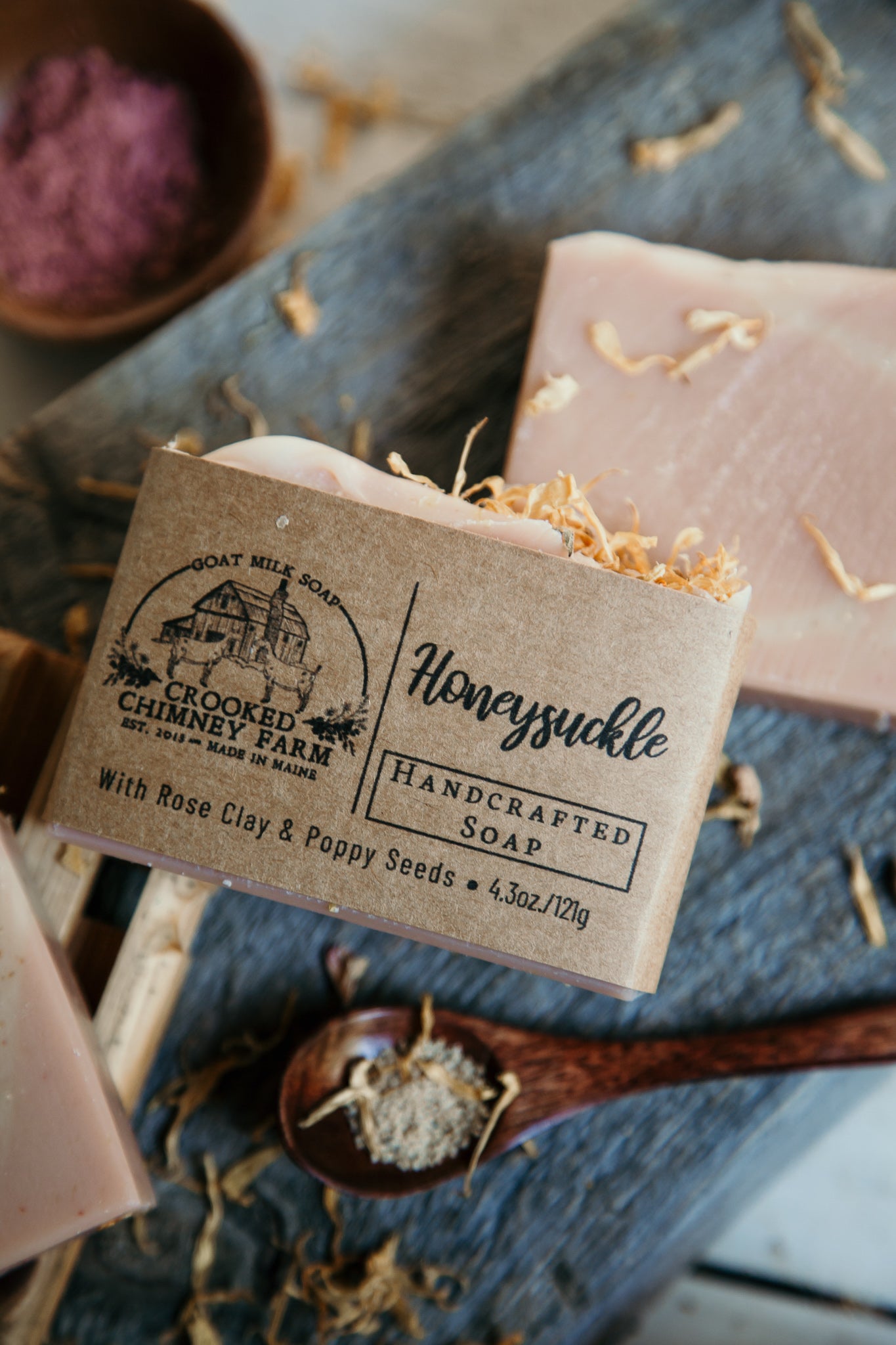 Honeysuckle goat milk soap bar. Pink soap with yellow flower petals on top. 