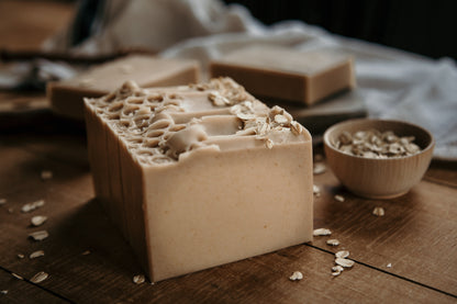 Oatmeal milk and honey goat milk soap bars. Tan soap with textured top with oats. Side view. 