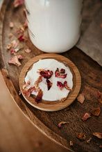 Load image into Gallery viewer, wild rose lotion spread on wood dish with red rose petals. 
